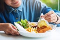 A female chef cooking and decorating a dish of fish and chips Royalty Free Stock Photo