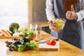 A female chef making and showing thumbs up hand sign while cooking fresh mixed vegetables salad in kitchen Royalty Free Stock Photo