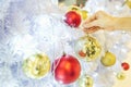 Closeup image of a hand decorating white snow Christmas tree with gold sparkling glitter baubles, disco crystal ball style. Royalty Free Stock Photo