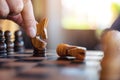 A hand holding and moving a horse to win another horse in wooden chessboard game Royalty Free Stock Photo