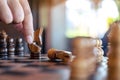 A hand holding and moving a horse to win another horse in wooden chessboard game Royalty Free Stock Photo