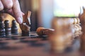 A hand holding and moving a horse to win another horse in wooden chessboard game Royalty Free Stock Photo