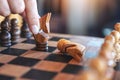 A hand holding and moving a horse to win another horse in wooden chessboard game Royalty Free Stock Photo