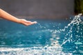 A hand splashing water in the pool