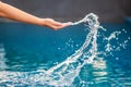 A hand splashing water in the pool