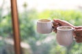 Hands holding two white cups of hot coffee with blurred nature background Royalty Free Stock Photo