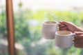 Hands holding two white cups of hot coffee with blurred nature background Royalty Free Stock Photo