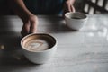 Hands holding two white cups of hot coffee on table in cafe Royalty Free Stock Photo