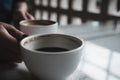 Hands holding two white cups of hot coffee on table in cafe Royalty Free Stock Photo