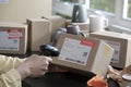 Closeup image of hands scanning barcode on delivery parcel. Worker scan barcode of cardboard packages before delivery at storage