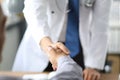 Closeup image of healthcare professional or doctor or dentist shaking hands with patient.