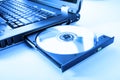 Closeup image of a laptop and a CD / DVD disc