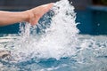 Legs and barefoot kicking and splashing water in the pool