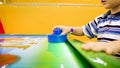 Closeup image of little boy`s hand playing in air hockey at shopping mall Royalty Free Stock Photo