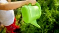 Closeup image of little boy watering flowers growing at garden Royalty Free Stock Photo