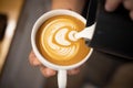 Closeup image of male barista holding and pouring milk for prepare cup of coffee. Royalty Free Stock Photo