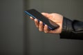 Closeup image of male hands with smartphone, searching internet or social networks, blurred background