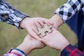 Closeup image of many people hands holding a jigsaw puzzle , cooperation in decision making, team support in solving problems and Royalty Free Stock Photo