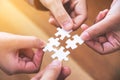 Many people hands holding and putting a piece of white jigsaw puzzle together Royalty Free Stock Photo
