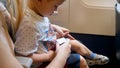 Closeup image of mother helping her toddler son fastening seat belt in airplane Royalty Free Stock Photo