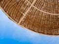 Closeup image of part of straw umbrella protecting from sun on the beach against blue sky. Pefect image for summer Royalty Free Stock Photo