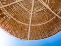 Closeup image of part of straw umbrella protecting from sun on the beach against blue sky. Pefect image for summer Royalty Free Stock Photo