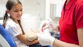 Closeup image of pediatric dentist explaining how to clean teeth on jaw model Royalty Free Stock Photo