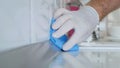 Closeup Image with Person Hands Wearing Protective Yellow Household Gloves Cleaning the Kitchen Furniture