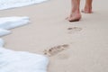 Closeup image of a person`s footprint while walking along the beach