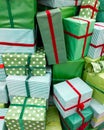 Closeup image of pile of lots of Christmas gifts. Stack of green boxes with red ribbons with New Year presents