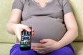 Closeup image of a pregnant woman hand holding remote control Royalty Free Stock Photo