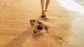 Closeup image of sexy barefoot female feet walking on the wet sand and calm warm waves at sea beach