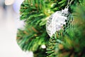 Silver mirrored mosaic Christmas ornament hanging on Christmas tree.