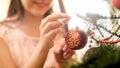 Closeup photo of smiling teenage girl hanging glass balls on Christmas tree Royalty Free Stock Photo