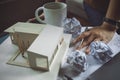 Closeup image of a stressed architects thinking and drawing shop drawing paper with architecture model and laptop on table Royalty Free Stock Photo