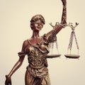 Closeup image of Themis goddess or lady justice holding scale blindfold on light background