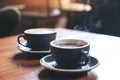 Closeup image of two blue cups of hot latte coffee and Americano coffee on vintage wooden table Royalty Free Stock Photo