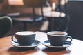 Closeup image of two blue cups of hot latte coffee and Americano coffee on vintage wooden table Royalty Free Stock Photo