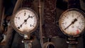 Closeup image of two rusty manometers with analog dials connected to vintage pipes of steam engine Royalty Free Stock Photo