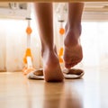 Closeup image from under the bed of female feet standing on wooden floor in bedroom Royalty Free Stock Photo