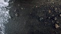 Closeup image of wet black volcanic sand and pebbles on ocean beach Royalty Free Stock Photo