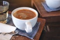 A white cup of hot coffee and a glass of tea on vintage wooden table in cafe Royalty Free Stock Photo