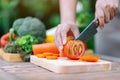 A woman cutting and chopping tomato by knife on wooden board Royalty Free Stock Photo