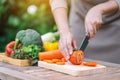 A woman cutting and chopping tomato by knife on wooden board Royalty Free Stock Photo