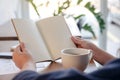 A woman holding and opening a blank notebook with coffee cup and papers on the table Royalty Free Stock Photo