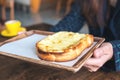 Closeup image of a woman holding a piece of sliced bread toast with cheese