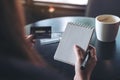 A woman holding a white blank notebook and credit cards on table Royalty Free Stock Photo