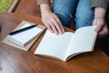 A woman opening a notebooks on wooden table Royalty Free Stock Photo