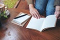 A woman opening a notebooks on wooden table Royalty Free Stock Photo