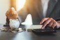 a woman putting coins in a piggy bank and calculating with calculator for saving money and financial concept Royalty Free Stock Photo